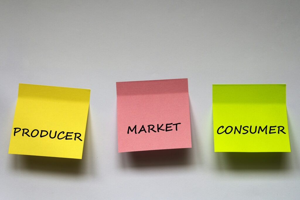 "Producer, market, consumer", the phrase is written on multi-colored stickers on white background